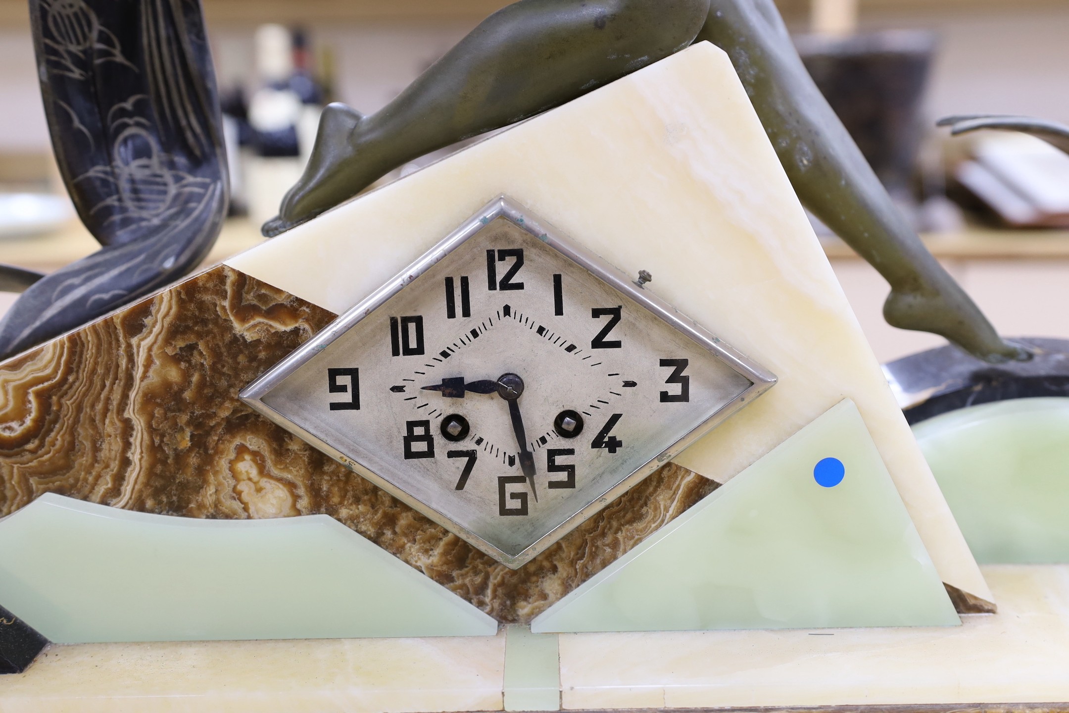 A large Art Deco spelter and marble clock garniture with a figural seaside mount, 59cm tall